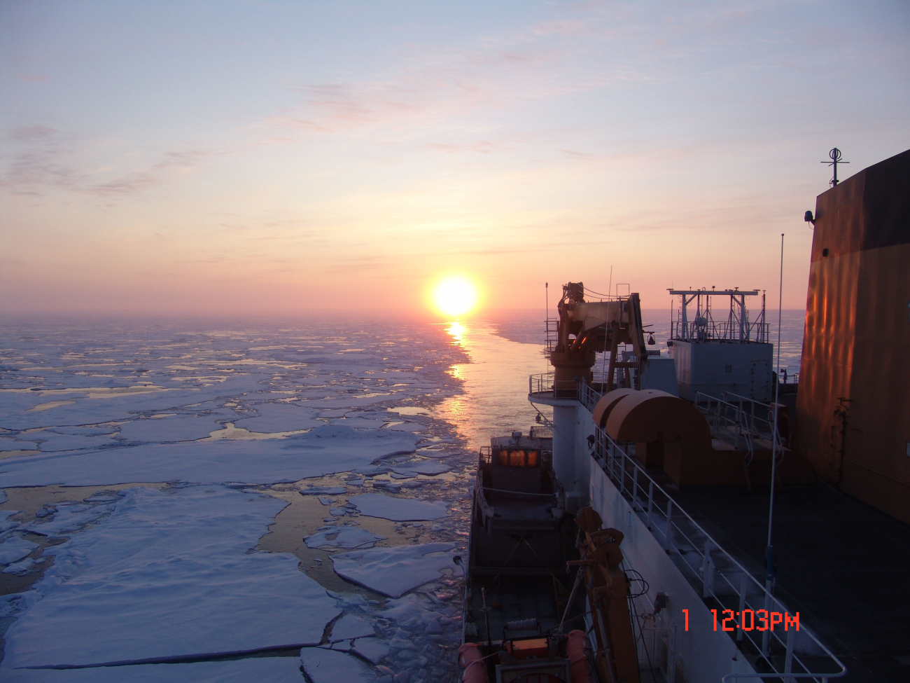 CGC HEALY passing through an area of first year ice floes with the sundirectly astern