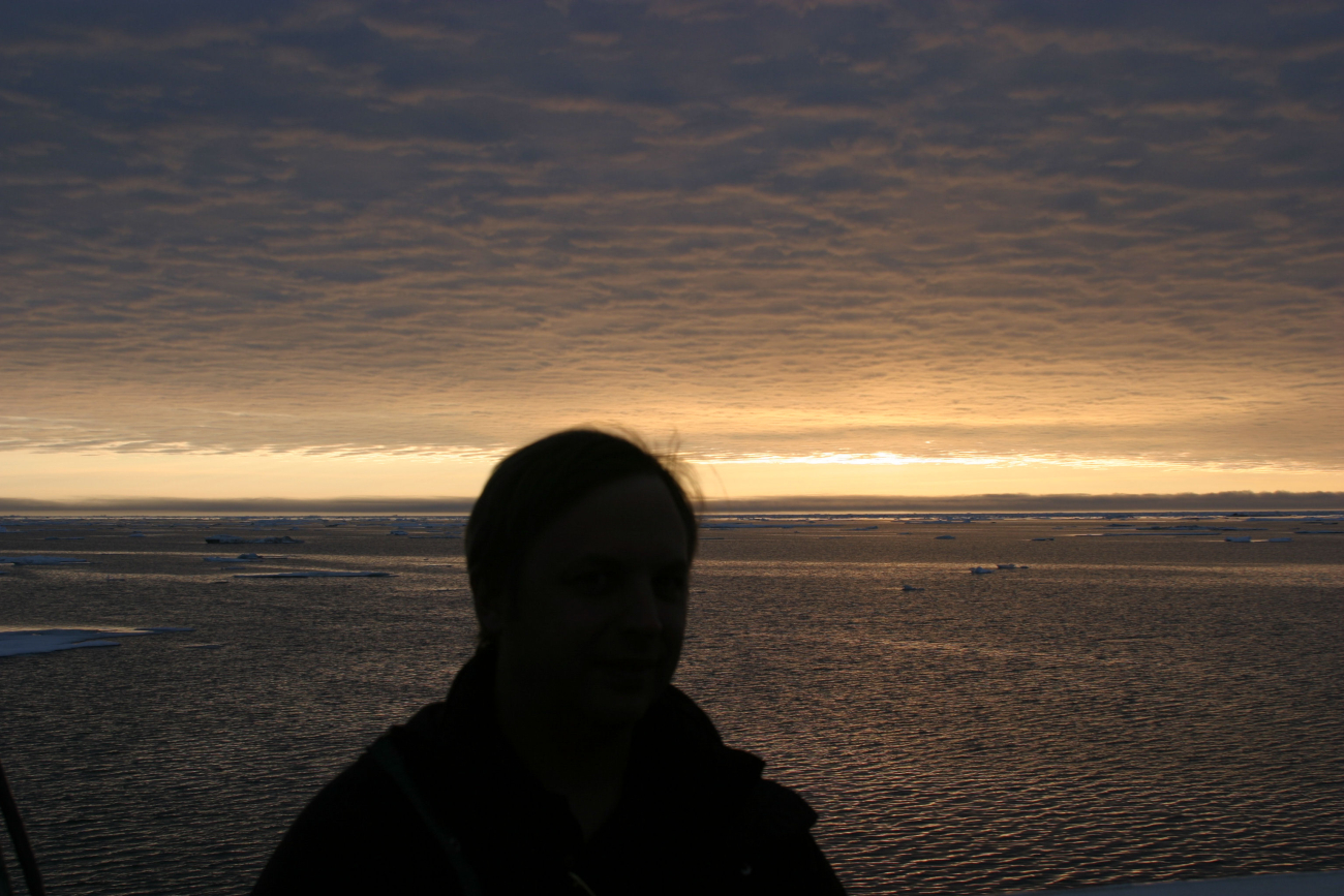 A lone observer with ice floes, open water, and an amazing display ofilluminated clouds