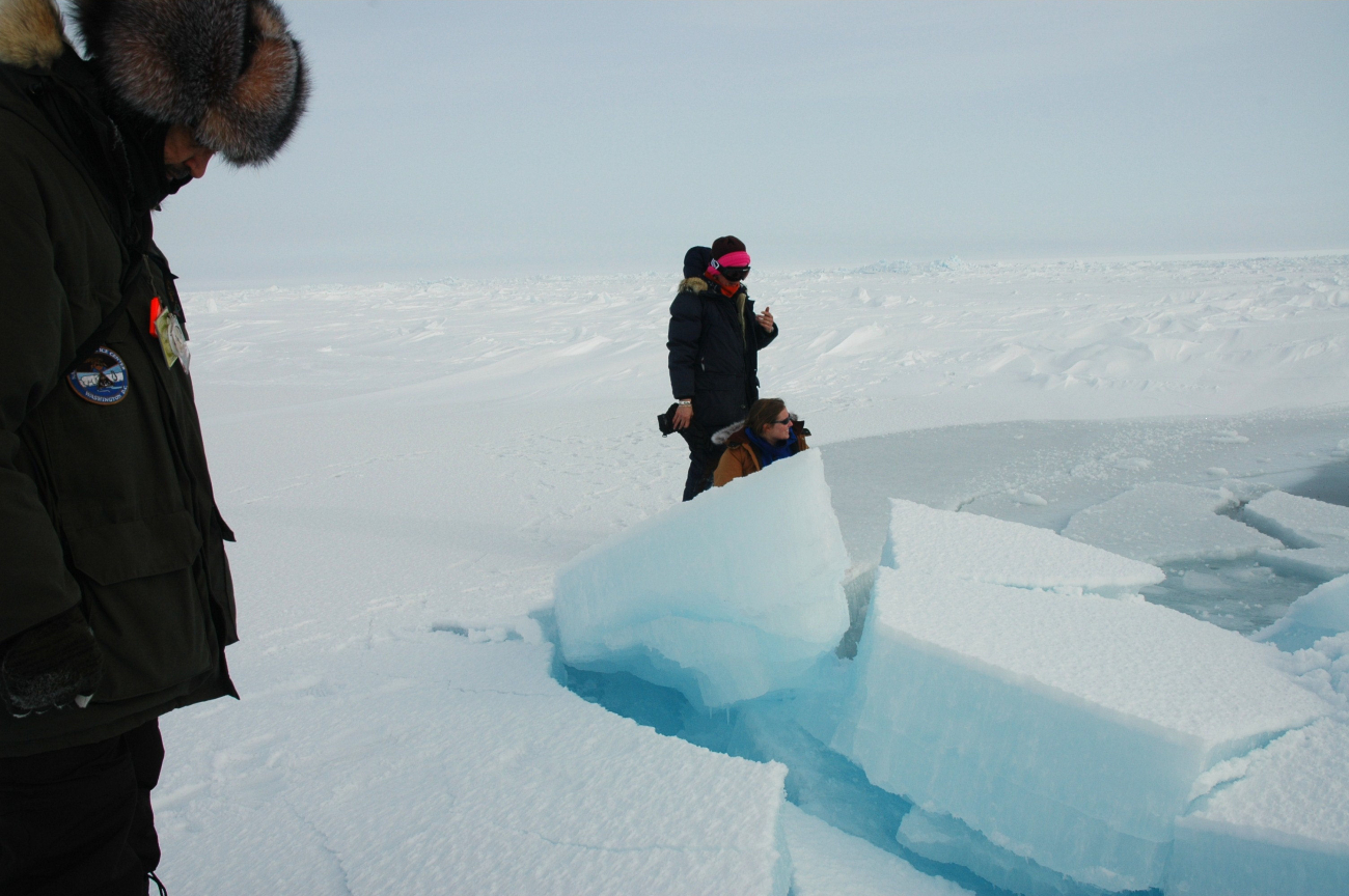Scientists inspecting blocks of ice on pressure ridge