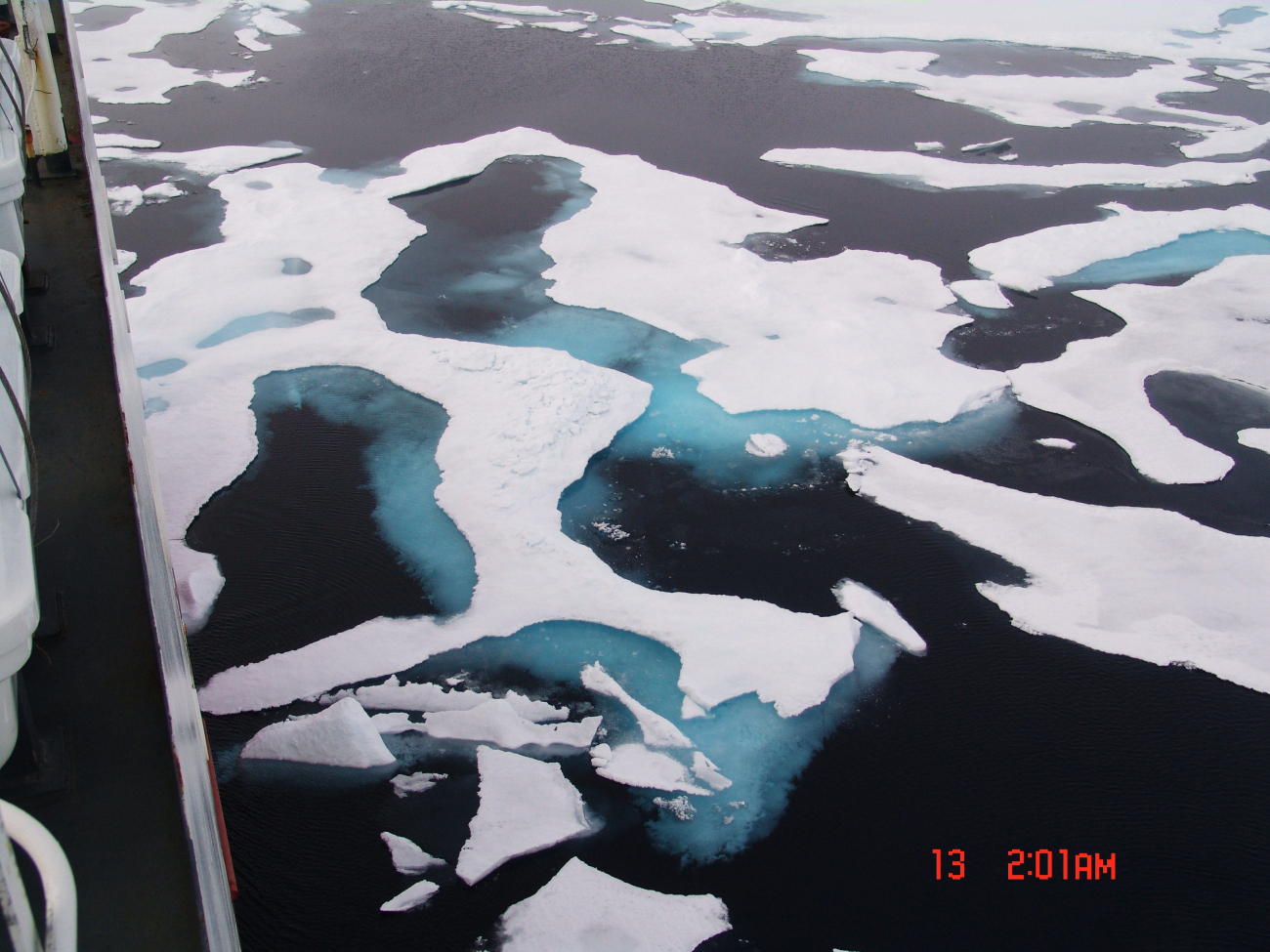 Deteriorating ice floes with melt pools, blue-green ice, and deep dark water inlate summer