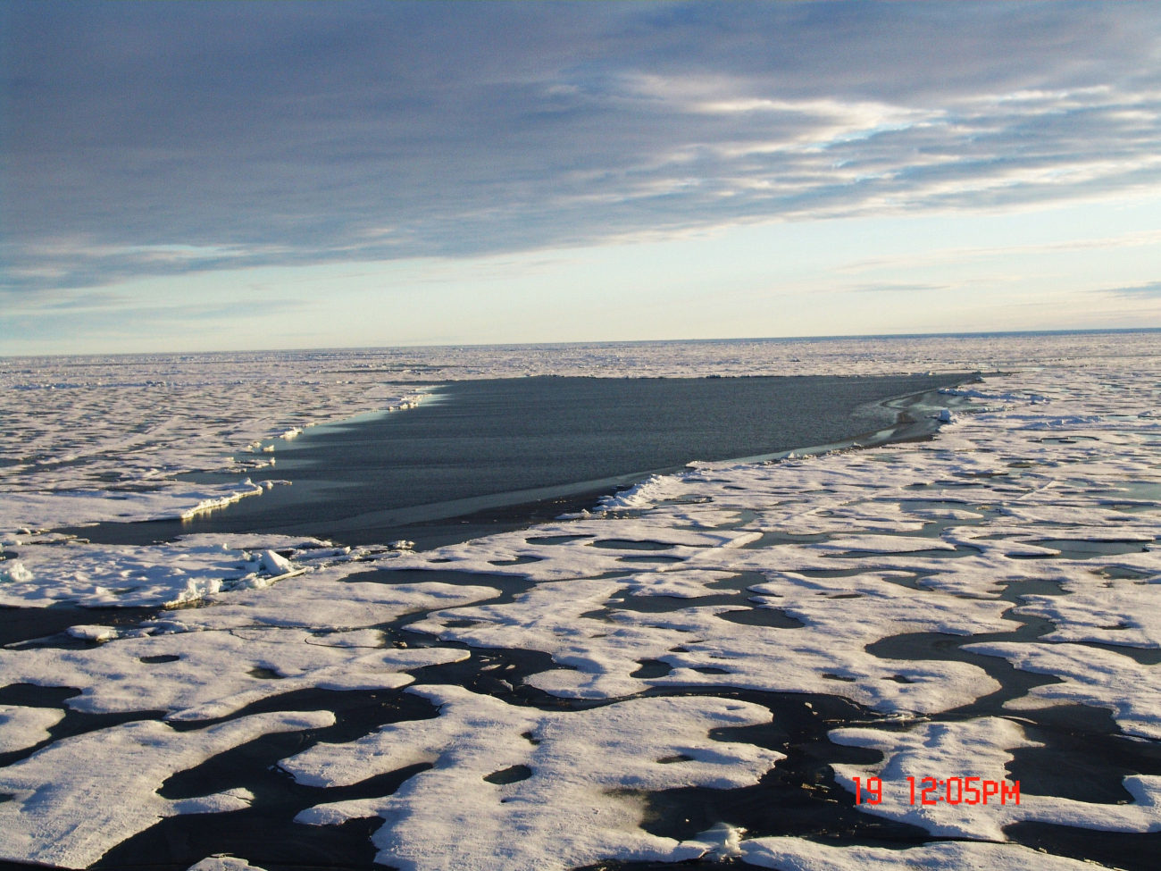 An area of hummocky 2nd year to multi-year ice with melt ponds with a smallpolynya