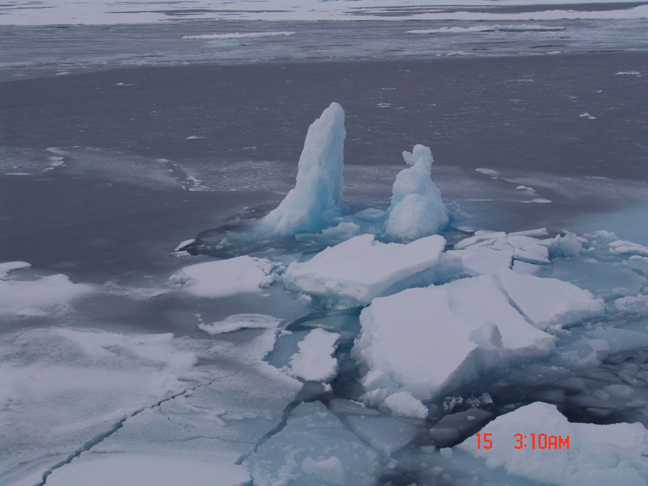 Large blocks of ice frozen in place while perpendicular to water surface