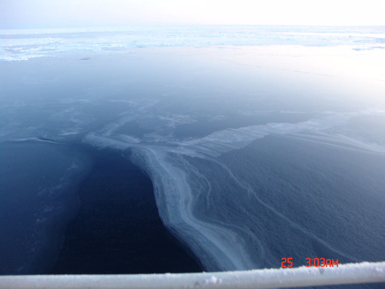 Frazil ice on lower left of image, nilas to right and ice floes extending tohorizon