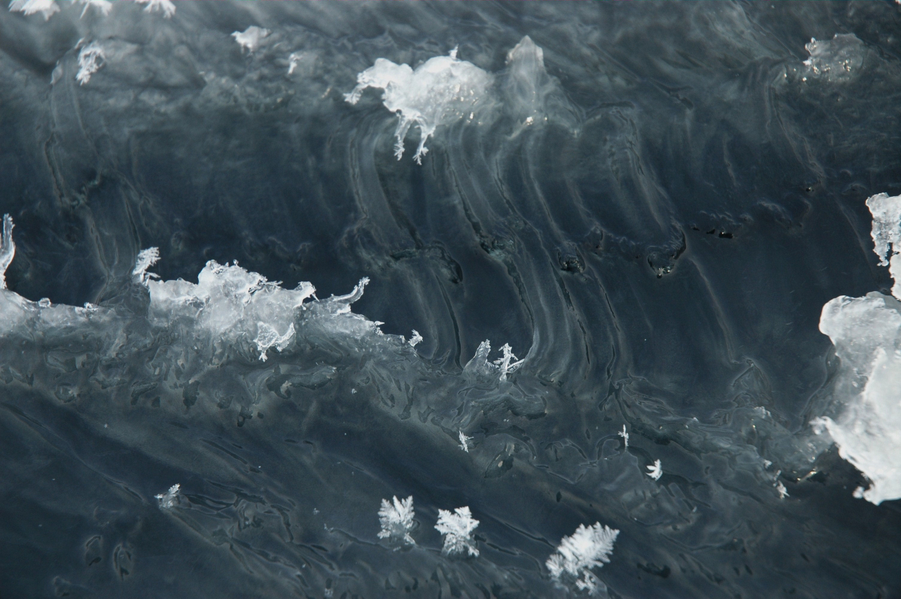 Ice crystals and patterns in the ice surface of refreezing water surface ofcrack in ice pack
