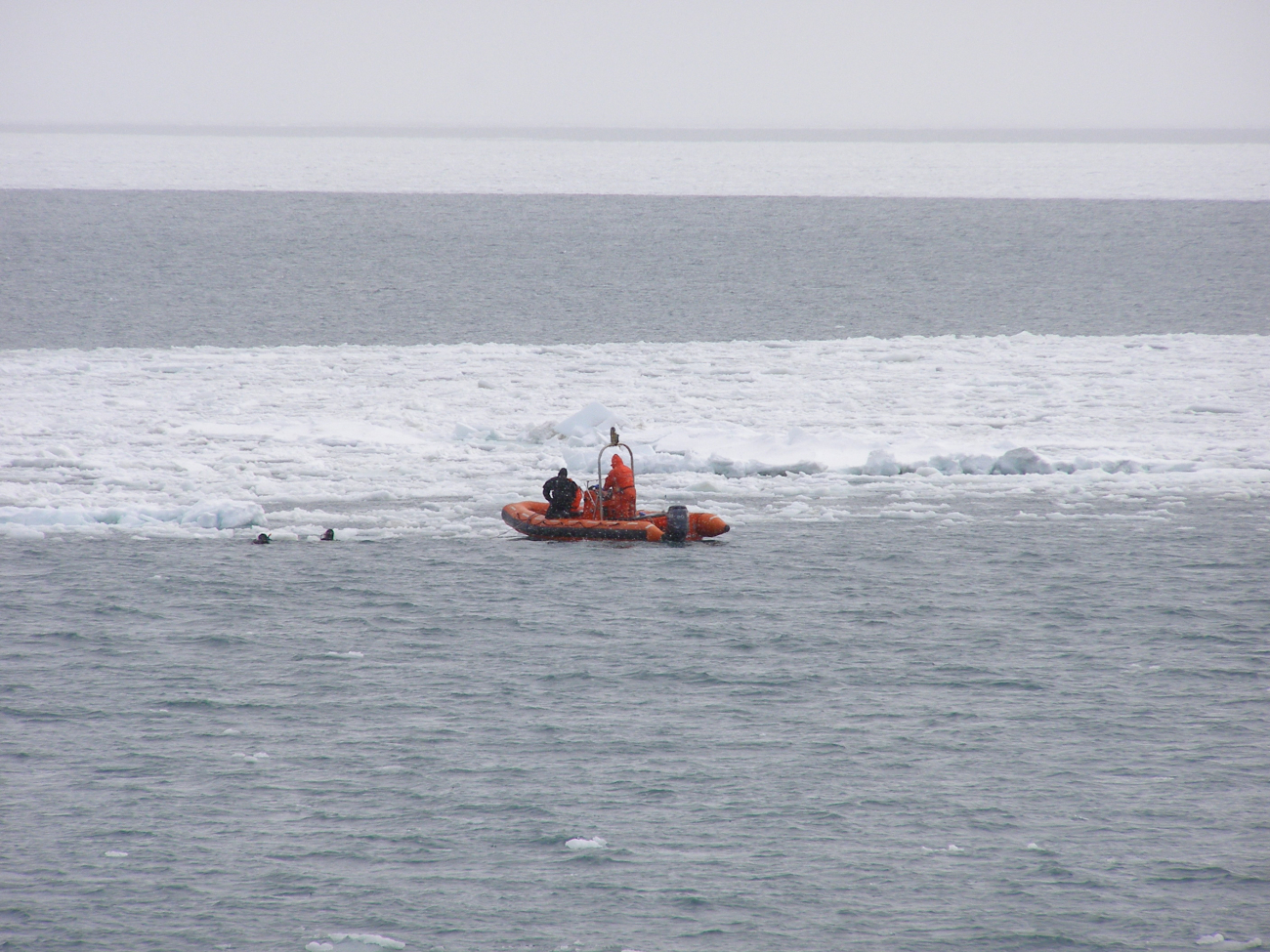 Divers from the MILLER FREEMAN being tended by small boat at edge of ice