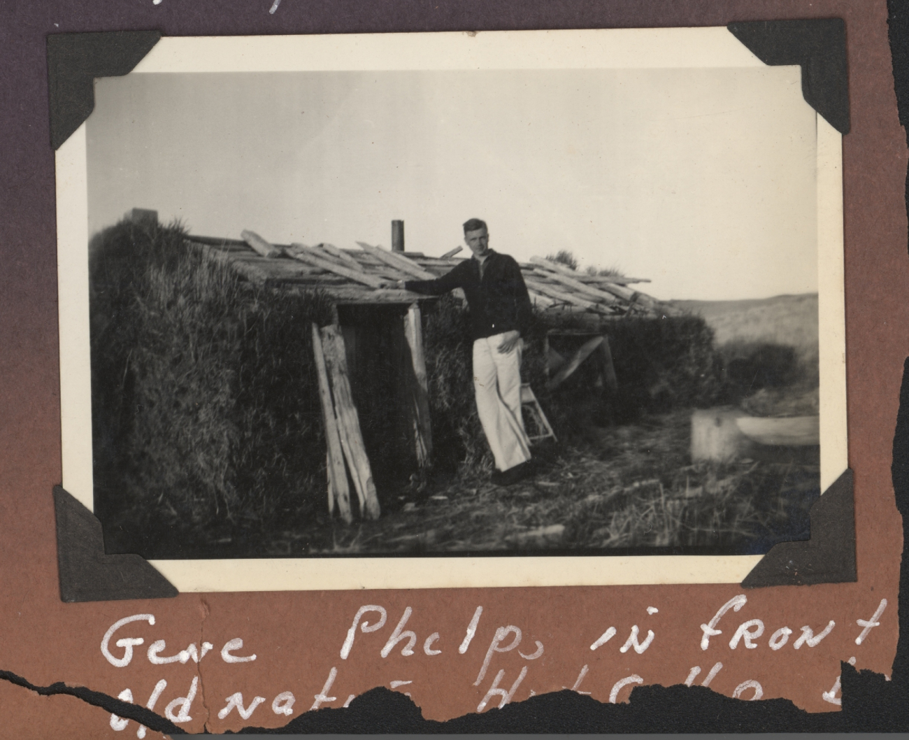 Gene Phelps in front of an old native Aleut hut