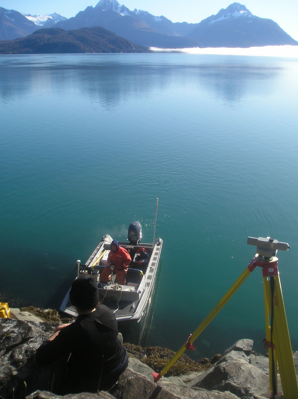 Small work boat waiting for surveyors to finish leveling a tide gage