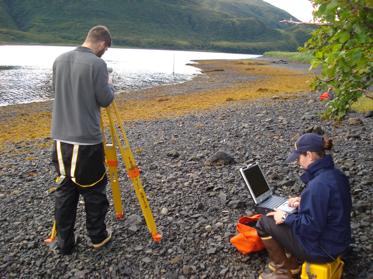 Assistant Survey Tech Eli Smith sets up for a leveling tide staff while EnsignMicki Ream prepares for data collection