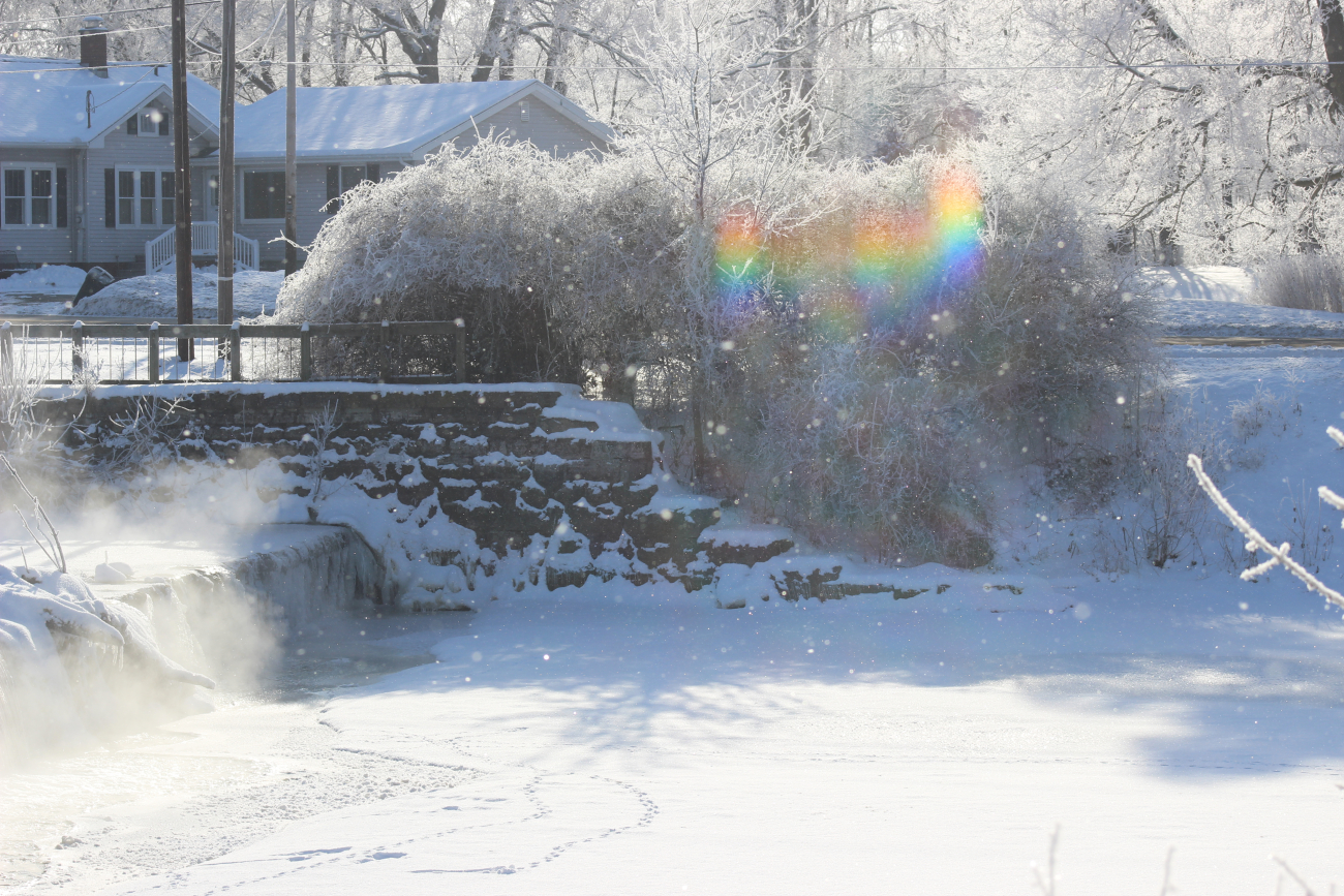 Frozen fog and falling snow meets rainbow