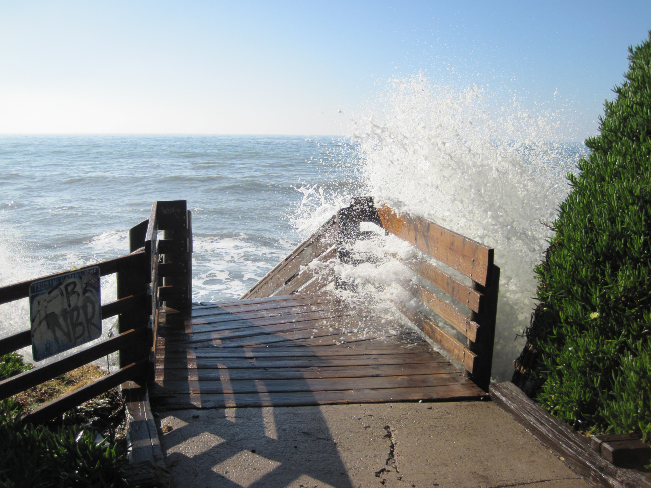 Waves crashing through a beach access stairwell in Isla Vista during the+6