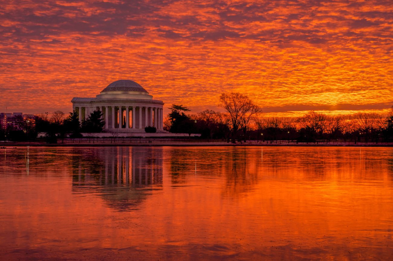 The Jefferson Memorial seen in a fiery Tidal Basin sunrise
