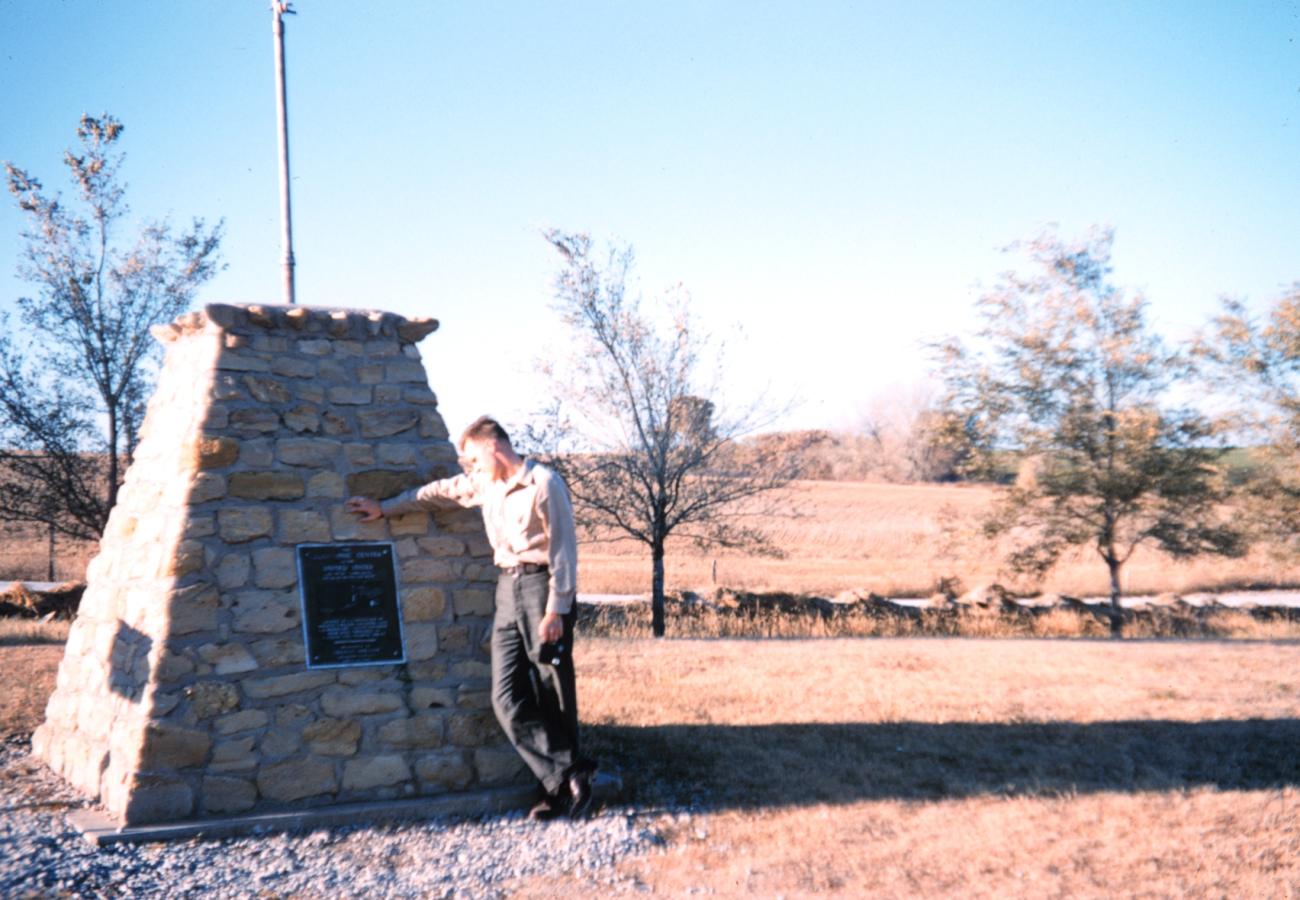 Harley Nygren reading marker indicating geographical center of United States
