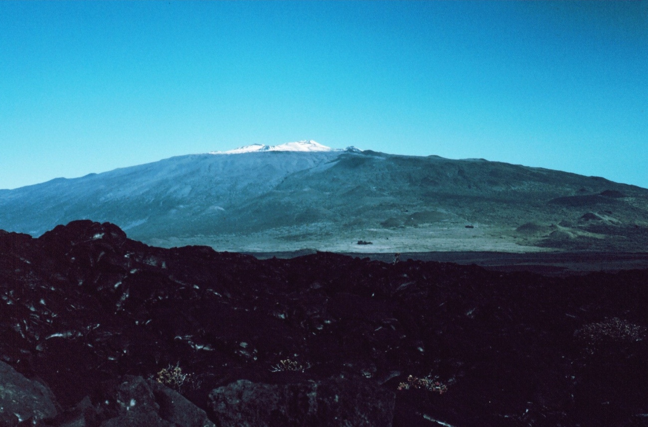 A view of snow-capped Mauna Kea as seen over an aa lava flow from Mauna Loa