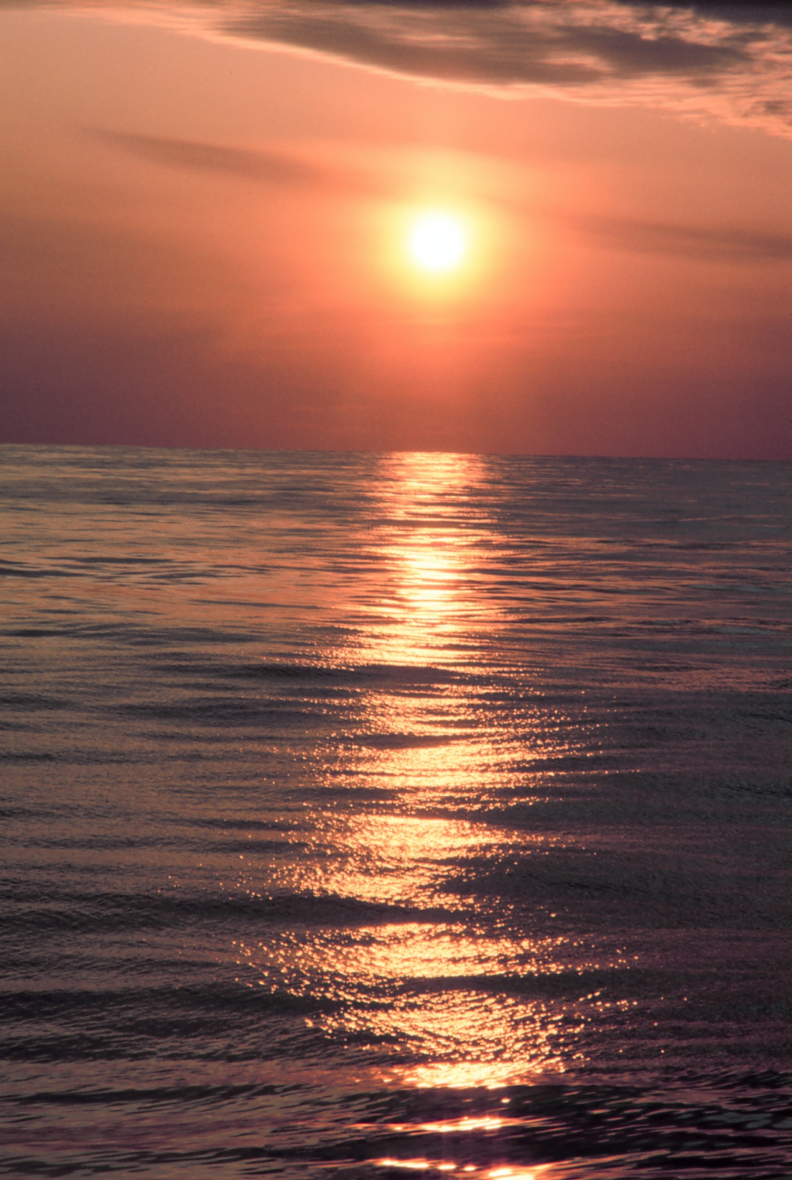 A streak of orange sunlight reflecting off the ocean at sunrise