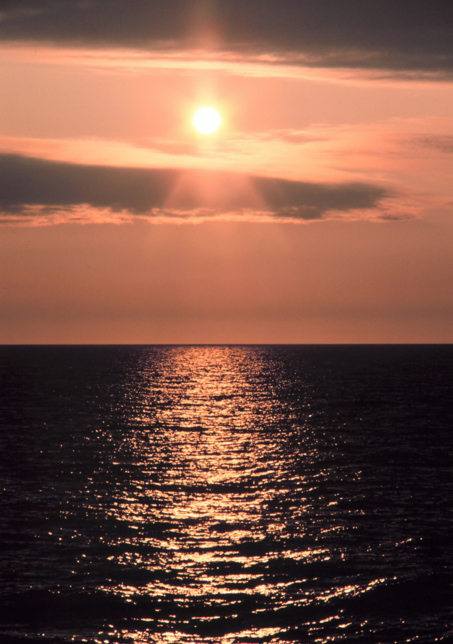 A streak of orange sunlight reflecting off the ocean at sunrise