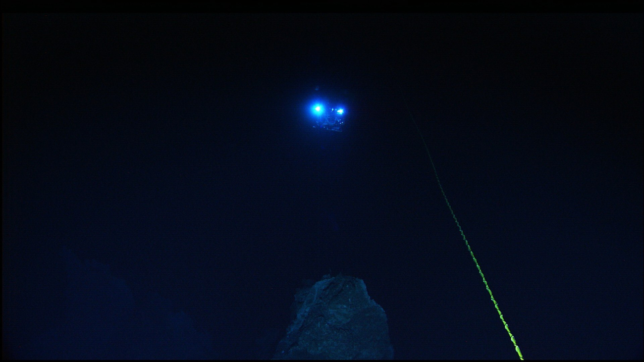 The lights from the Hercules ROV are seen 30-meters away as theROV is maneueved in the vicinity of a rock outcrop