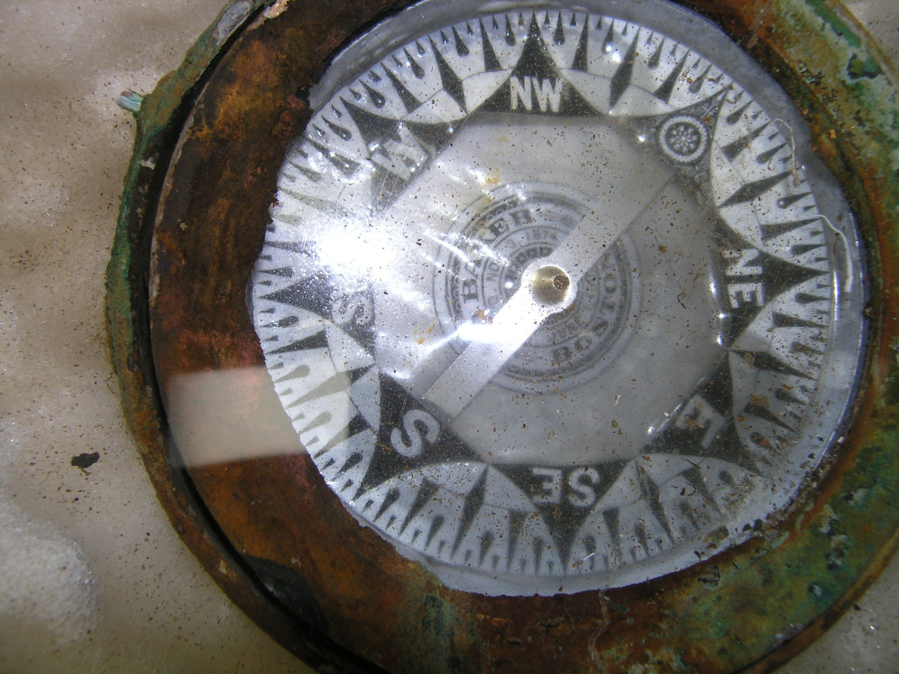The card of the compass is still intact revealing the manufacturer and date ofthe compass patent