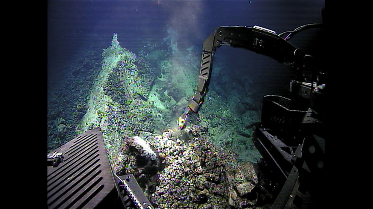 The manipulator arm of Deep Discoverer sampling a rock at a hydrothermal vent