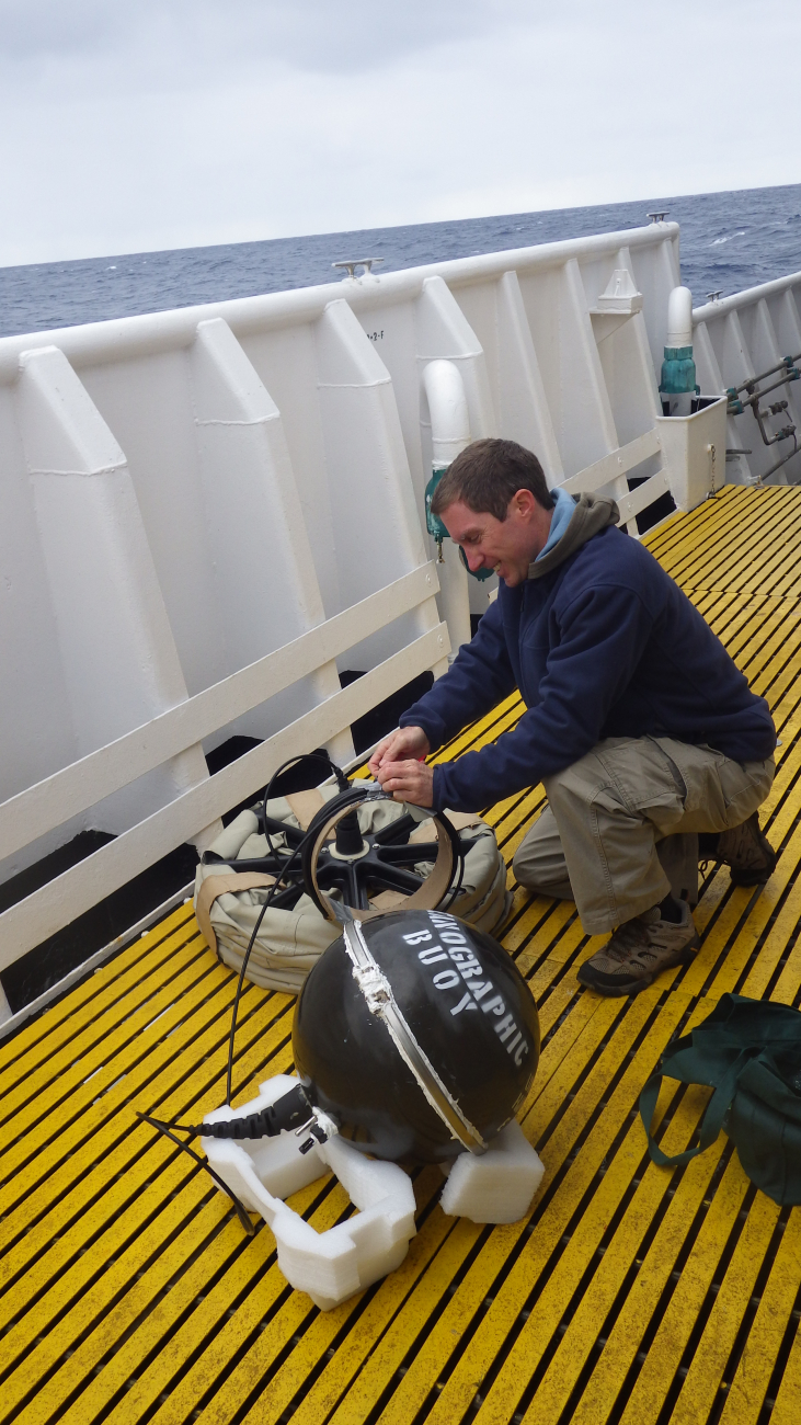 Lucas Moxey, one of the scientists onboard the NOAA Ship Oscar Elton Sette,preparing the drifter buoy for its ocean deployment at 30