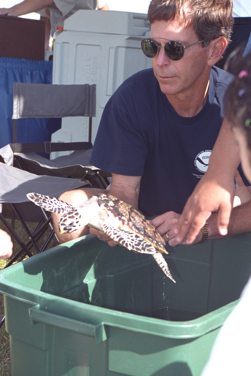 Pete Sheridan holding a turtle for people at our local Bay Day Festival heldannually