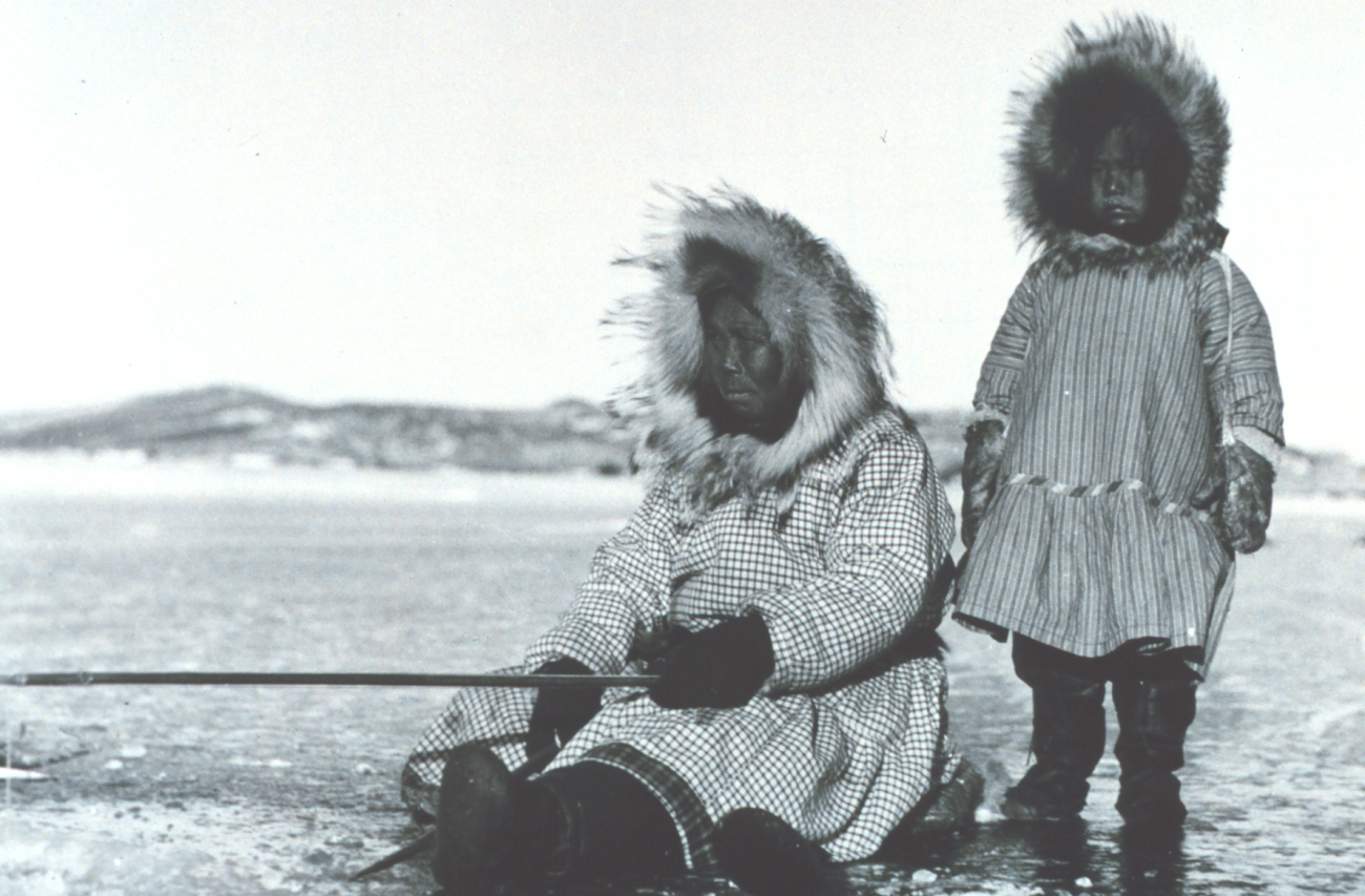 Eskimo woman and child ice fishing in the Bering Sea