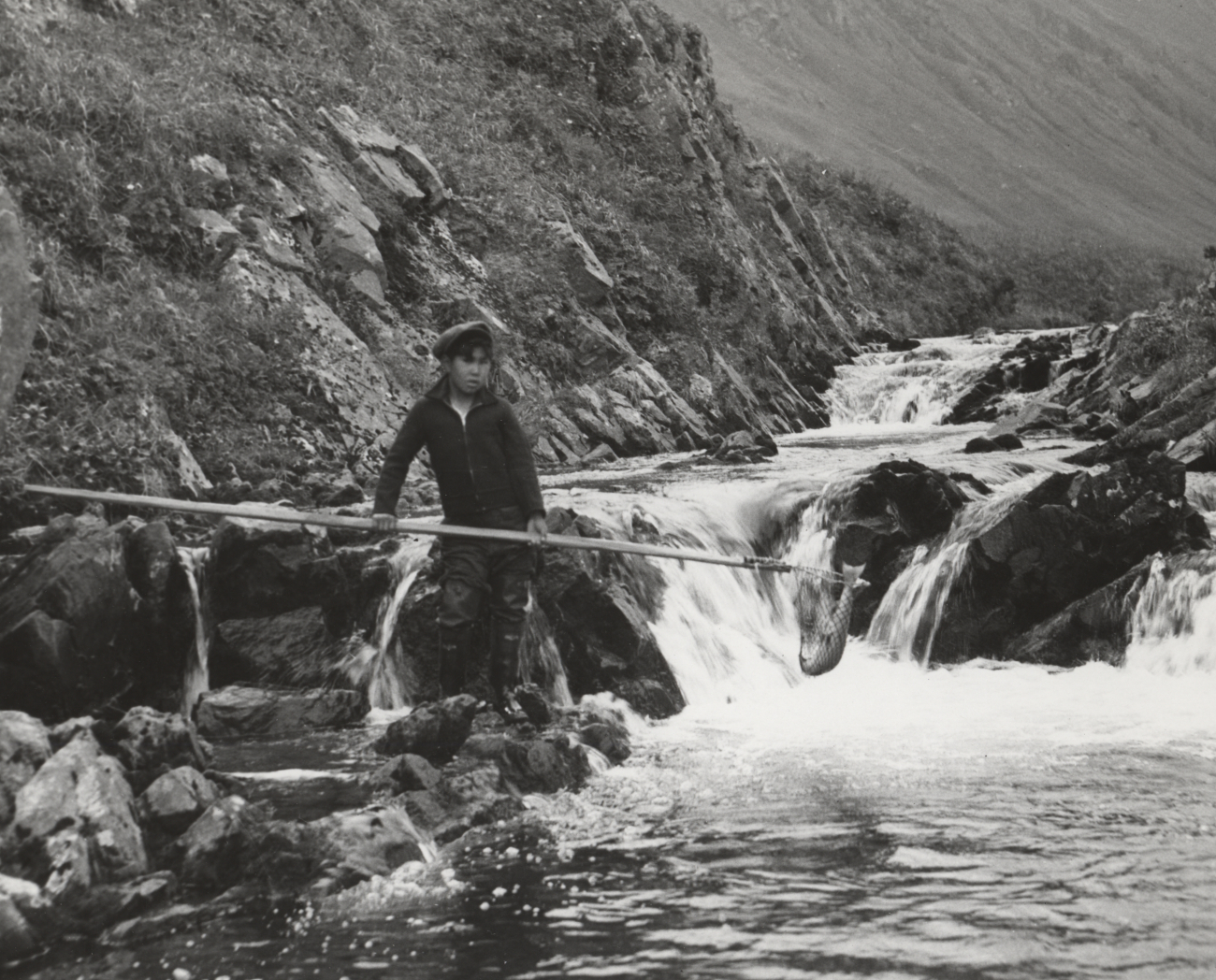 Mike Houdikoff's son netting sockeye salmon on creek above village
