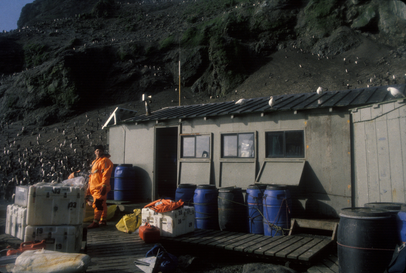 An AMLR scientist stands in front of the food storage building