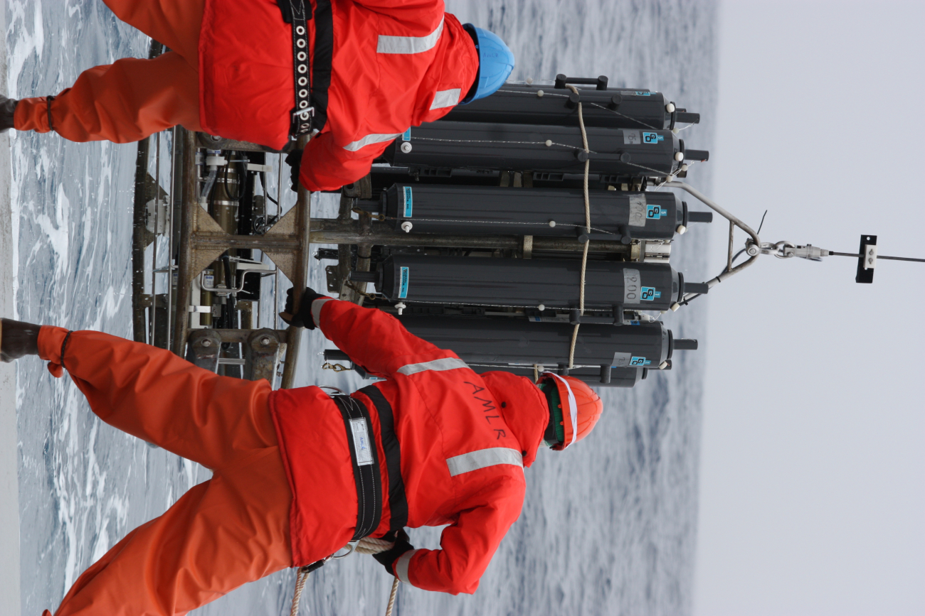 AMLR crew members lower equipment into the frigid ocean