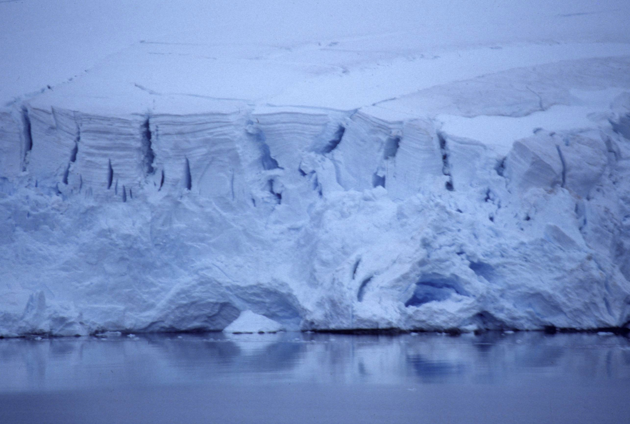 The NOAA Ship R/V Surveyor steams north past an iceberg and Elephant Island (left)