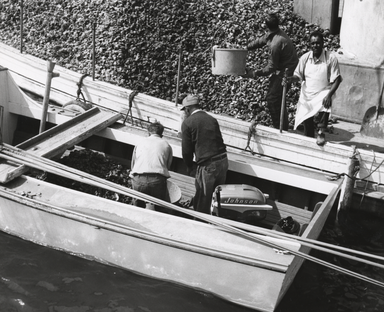 Oyster tonger unloading his catch on buy boat