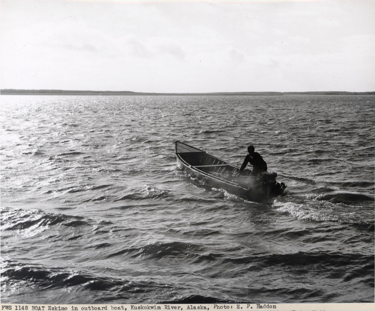 Eskimo in boat with outboard motor on Kuskokwim River