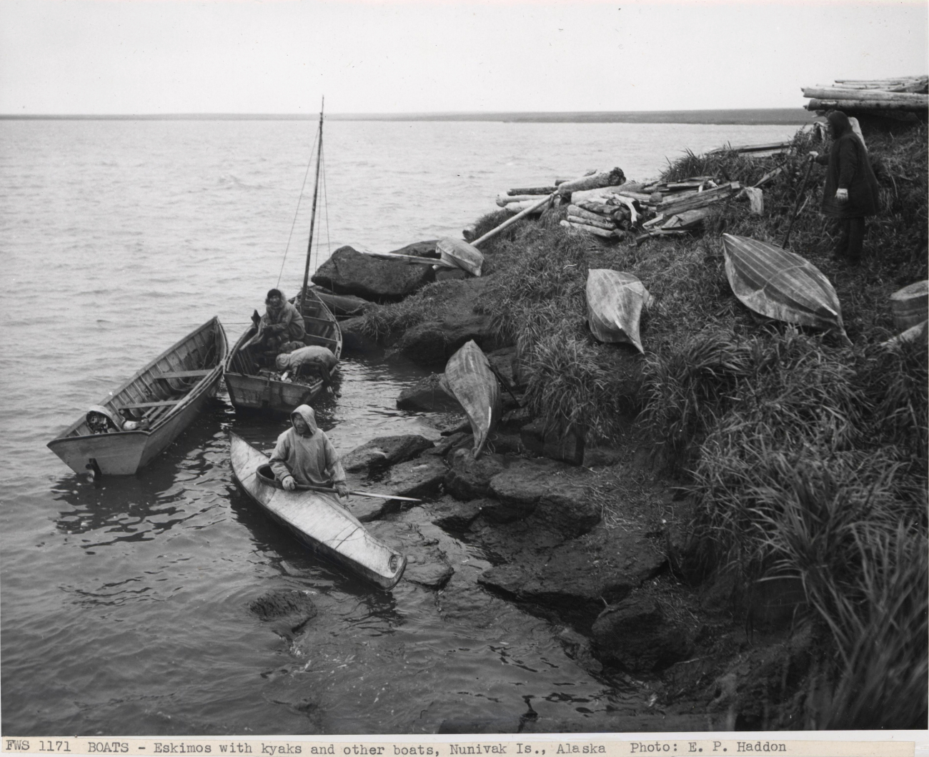 Eskimos with kayaks and other boats