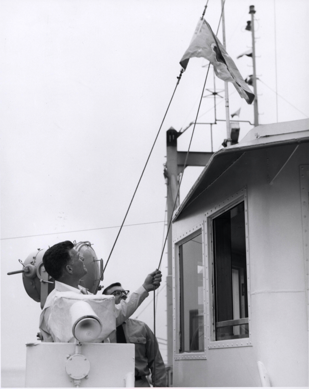 Raising the official flag of the Department of the Interior during dedicationceremonies on the ALBATROSS IV