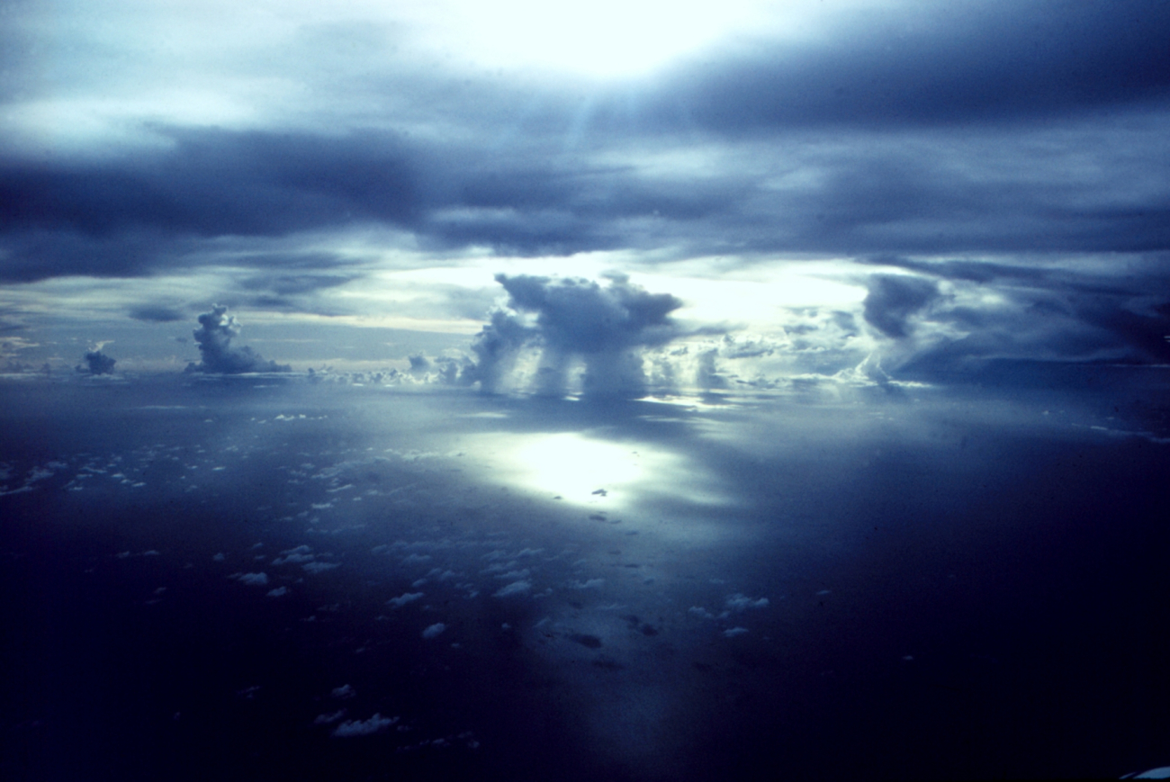 Puffy cumulus, cumulus congestus, and sun peaking through a hole in theclouds over the tropical Atlantic