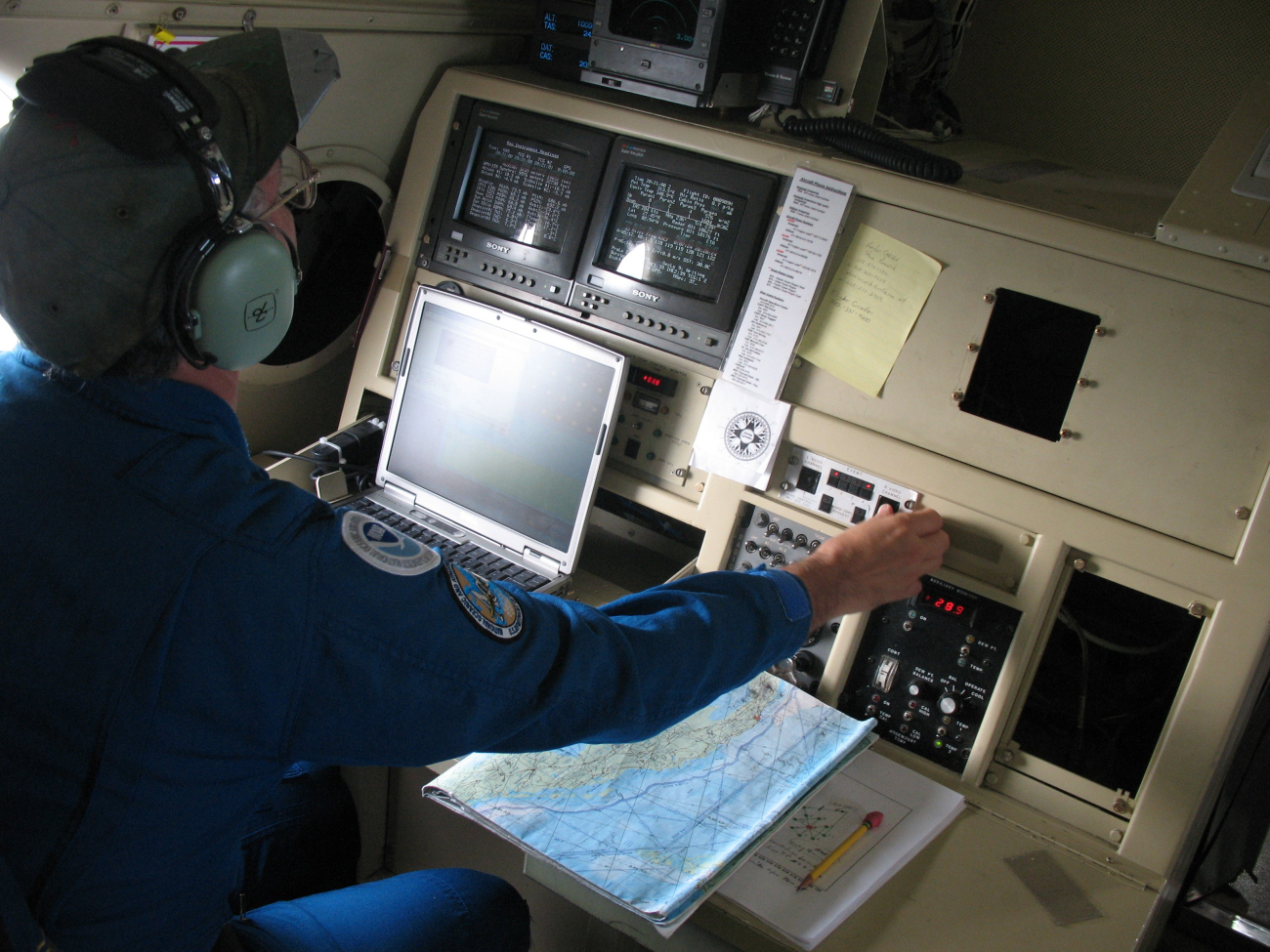 Scientist monitoring computers and instruments during flight into Hurricane Ike