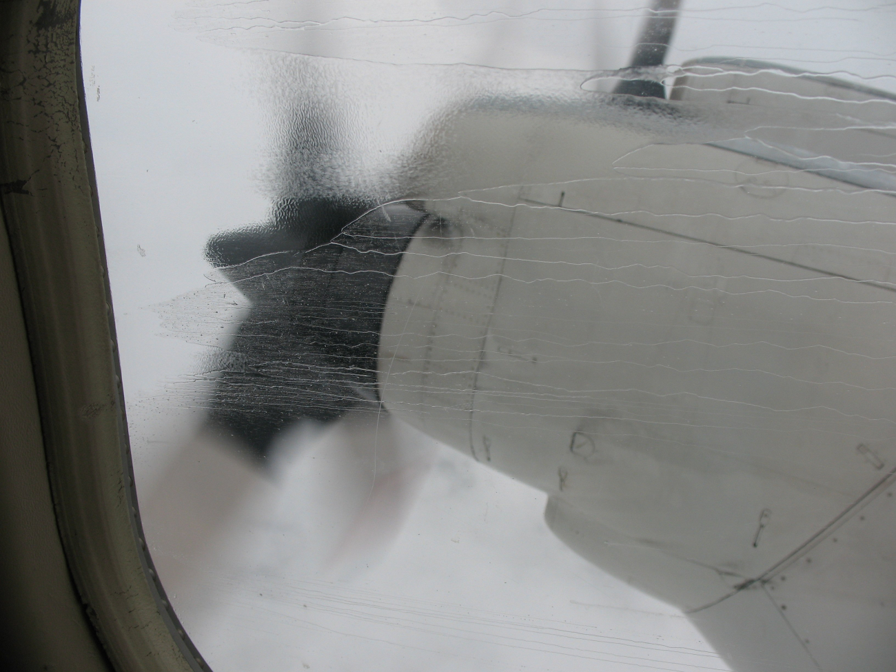 Rain streaks on a starboard side P-3 window while flying into a hurricane