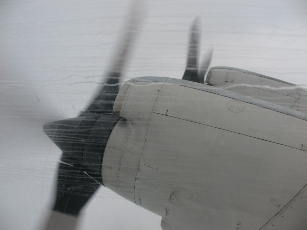 Rain streaks on a starboard side P-3 window while flying into heavy storms