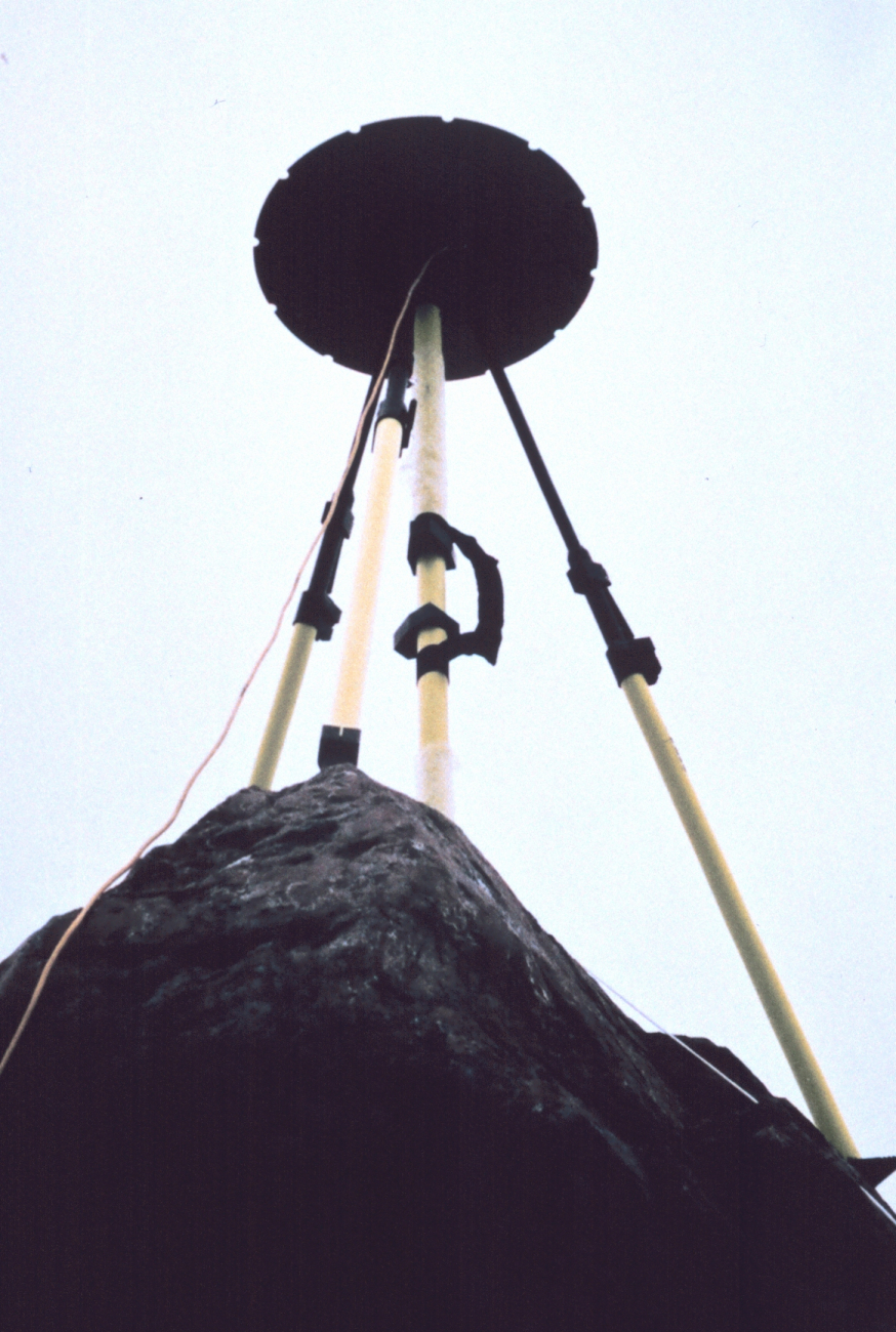 GPS antenna and tripod set up over tidal bench mark on rock