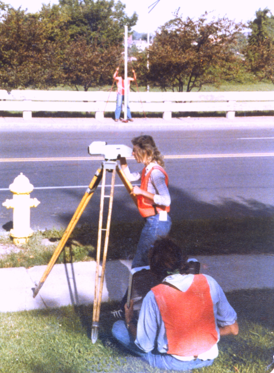 Anita Whitis observing on a level rod to left, while second rodman waits forreading across street