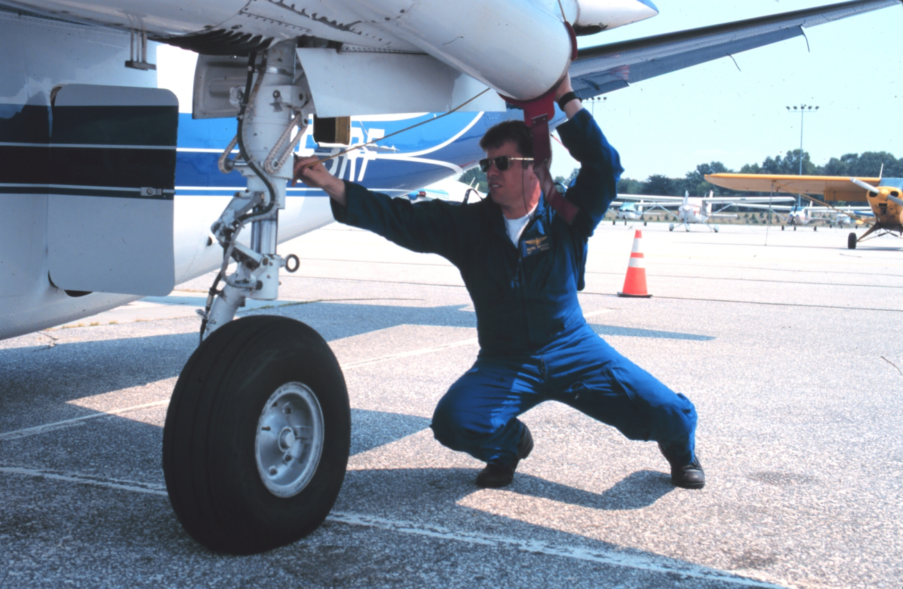 Lieutenant Commander Greg Lamontagne taking care of details that make for safe flights on Rockwell Turbo Commander N53RF