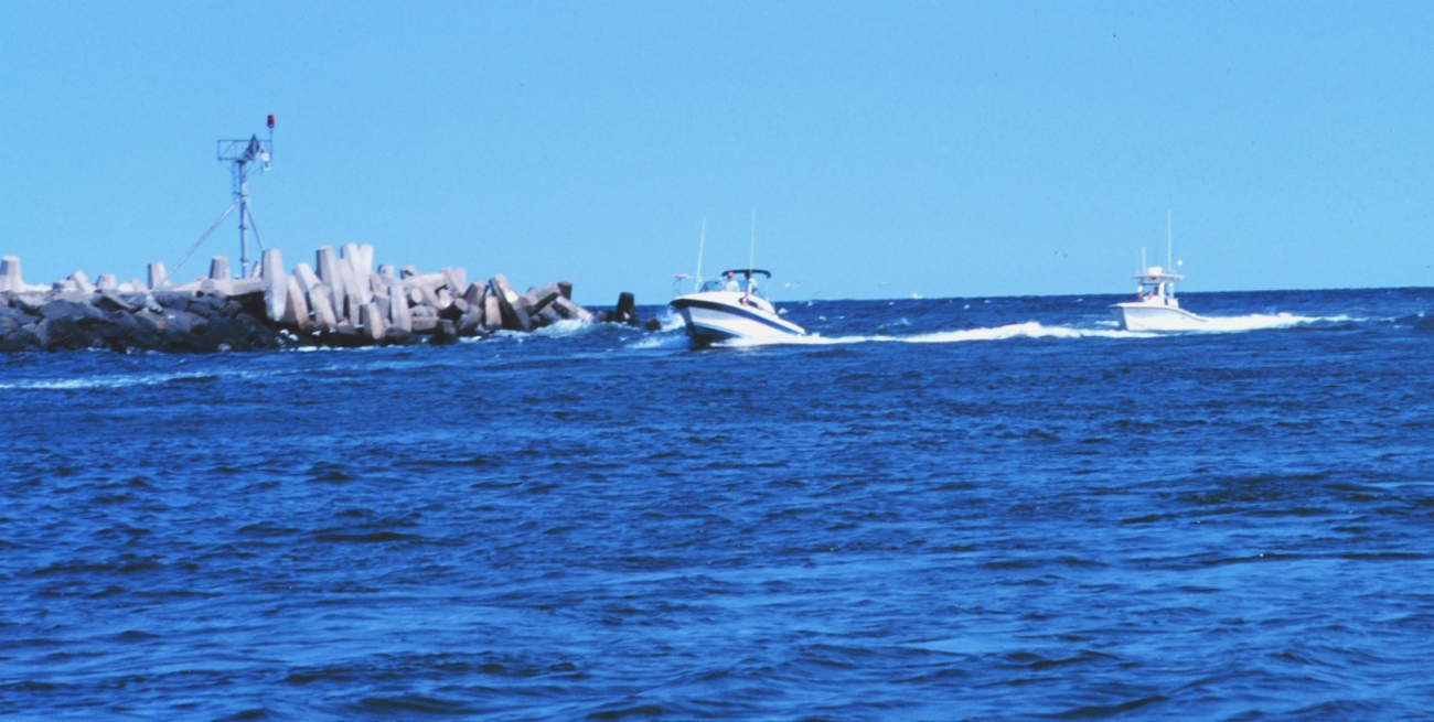 Recreational fishing boats passing the jetties at Manasquan Inlet
