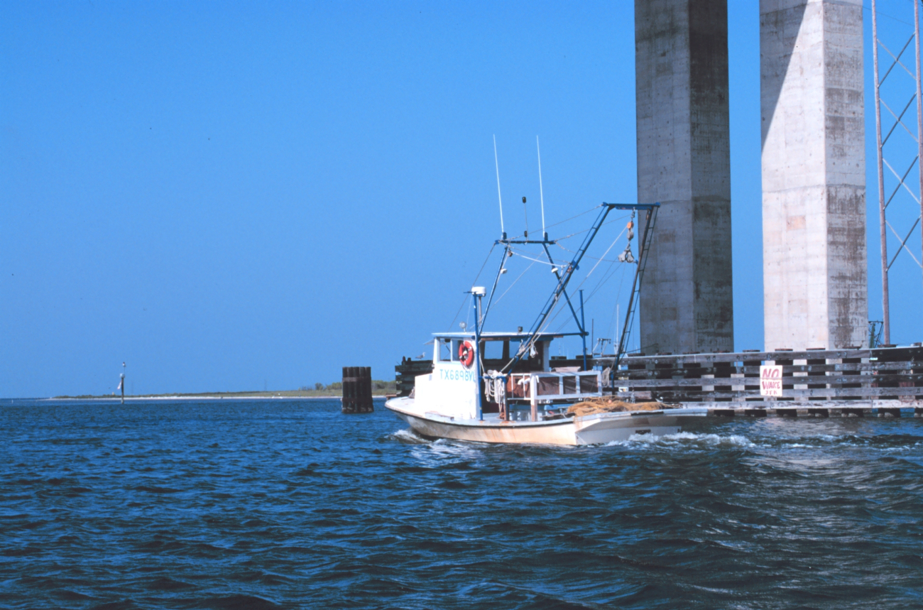 A shrimp boat headed north along the Intracoastal Waterway passing under the JFK Causeway