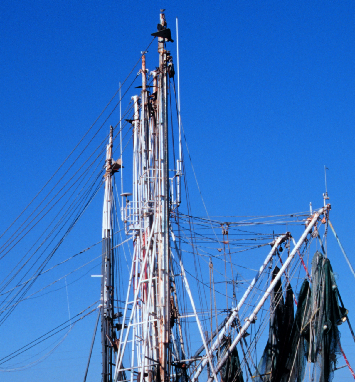 Masts and booms of shrimp boat with nets drying