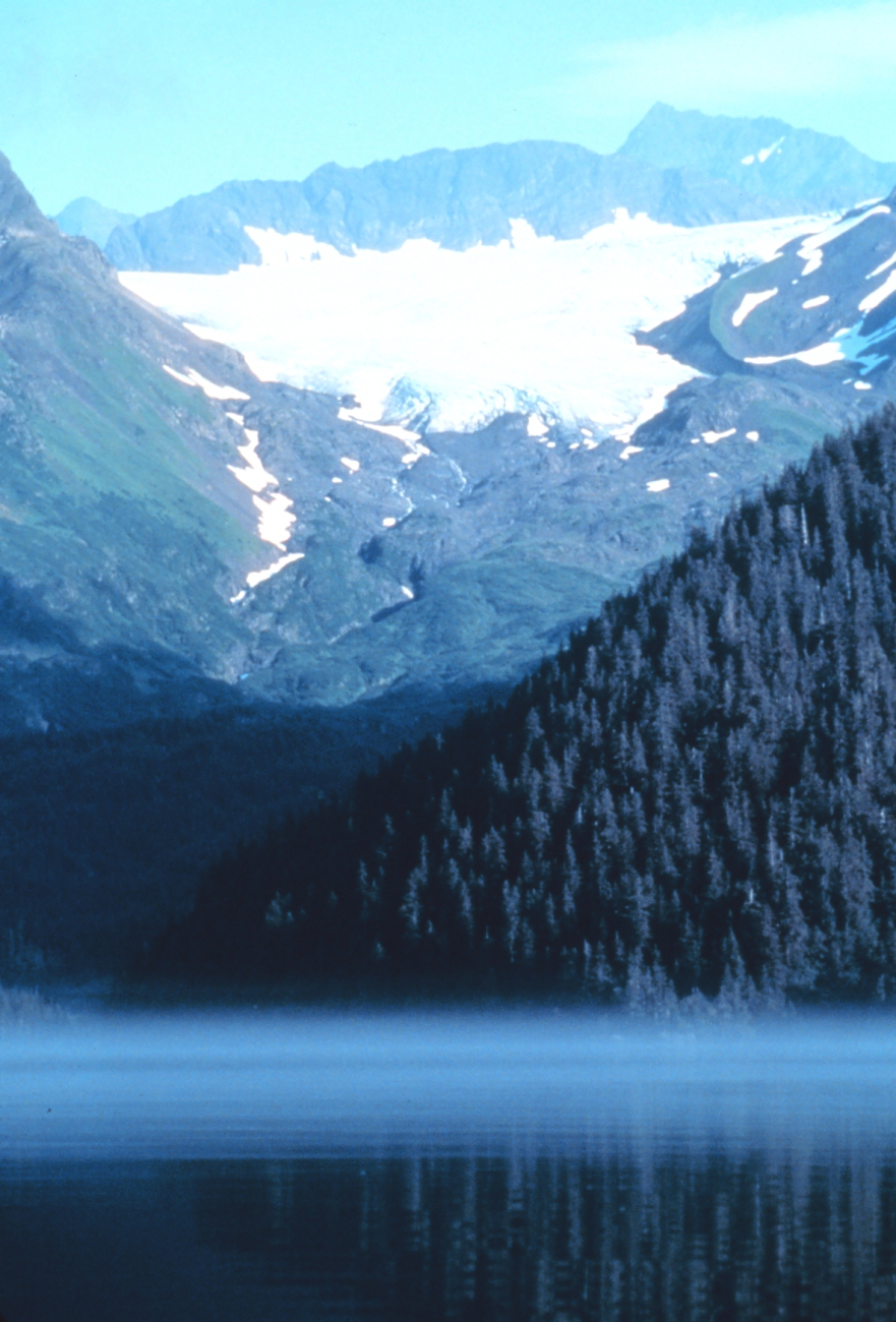 Mist below and glacier above while a high rocky peak dominates all