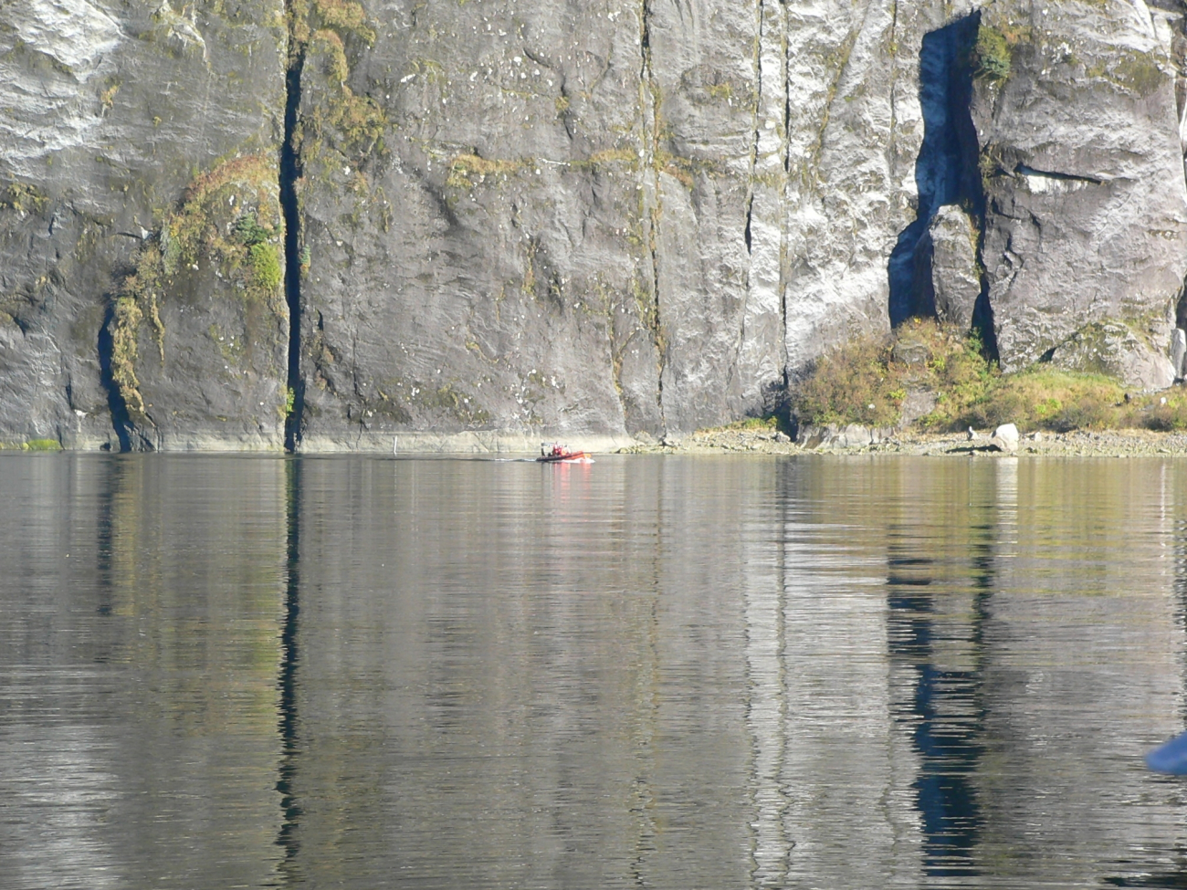 FAIRWEATHER's rigid-hull-inflatable boat (RHIB) dwarfed by the cliffs inRudyerd Bay area