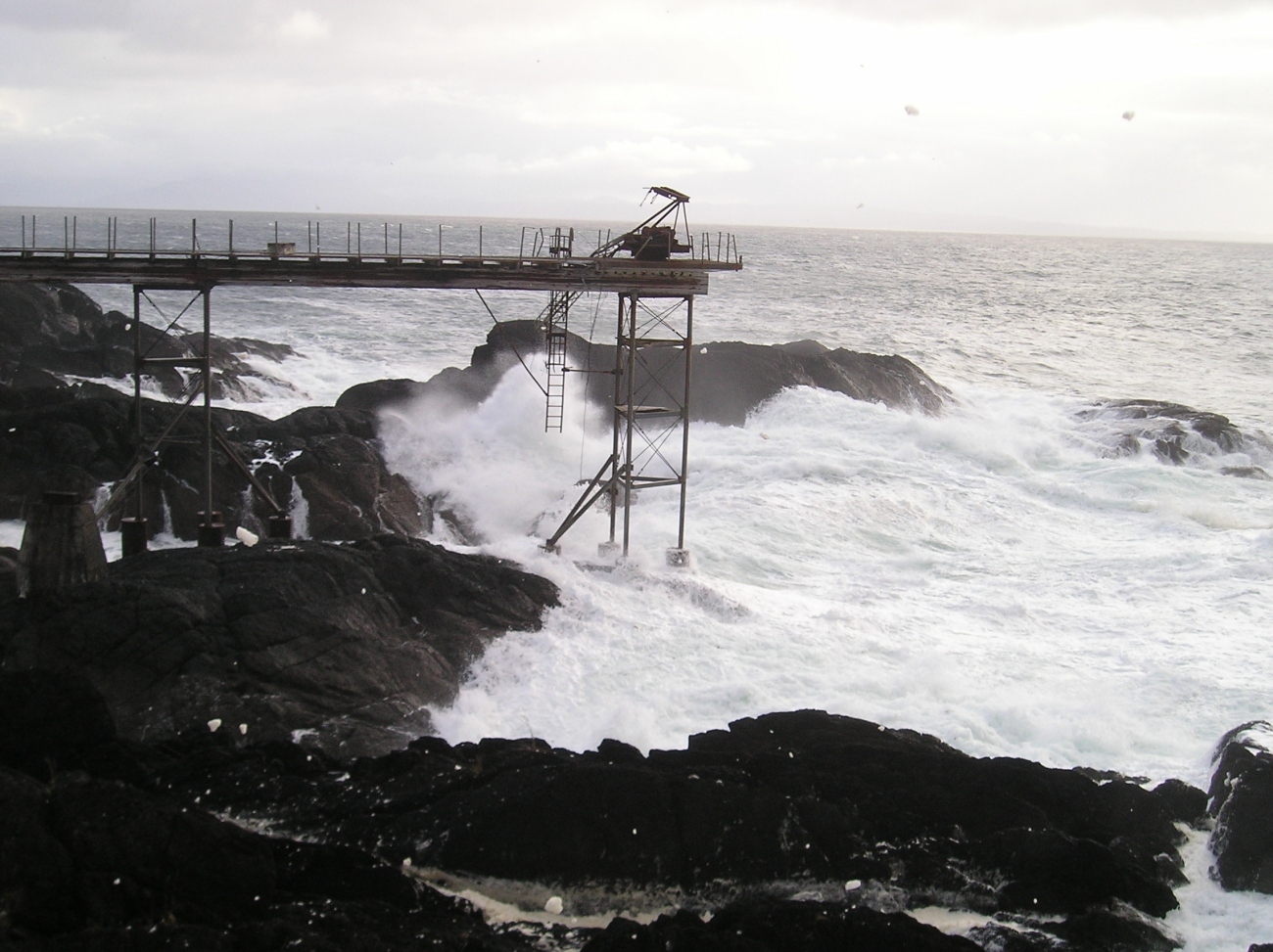 Surf roars over the remains of the old Coast Guard Pier at Cape Decision