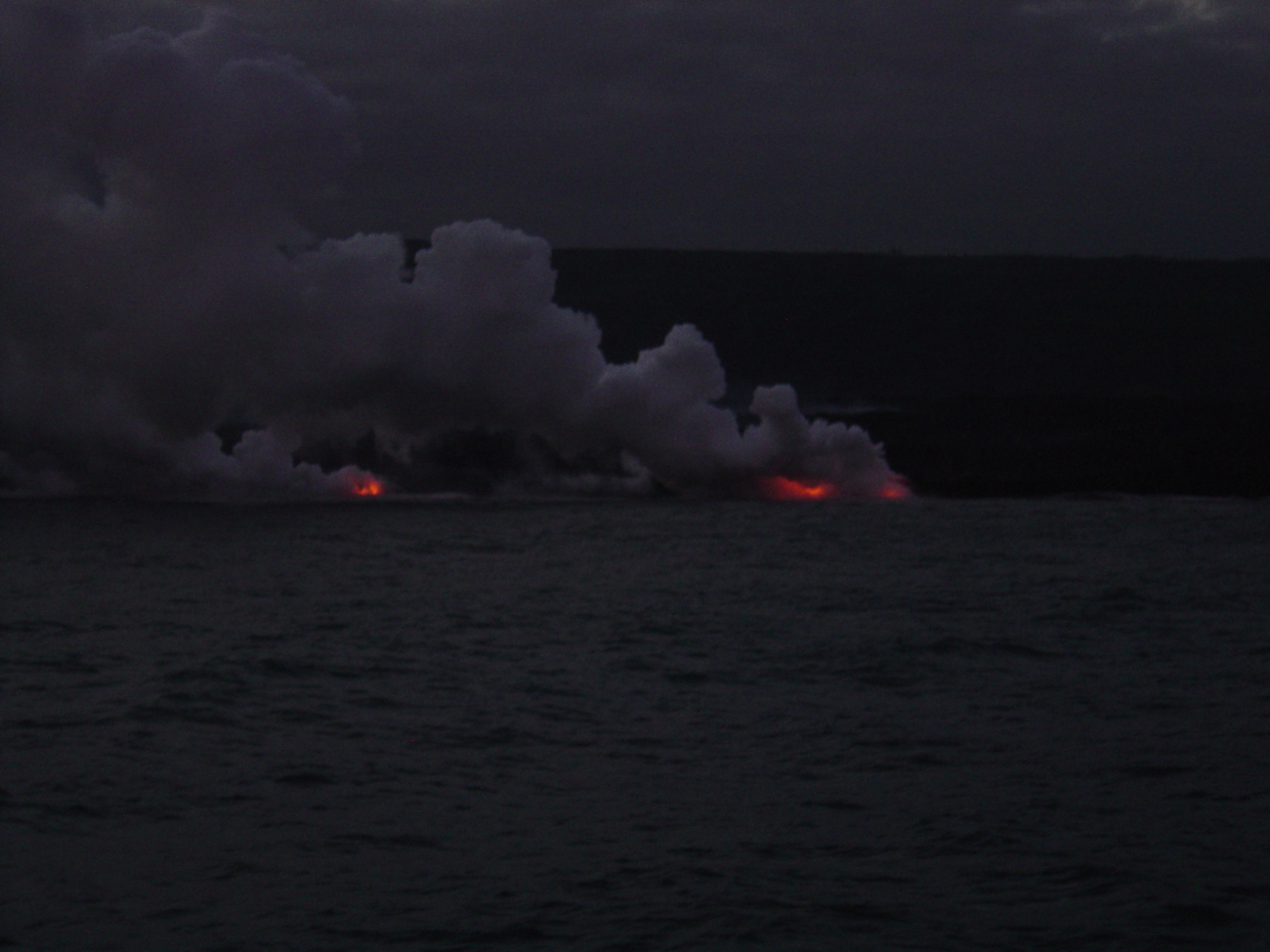 Lava flow entering the sea at night on SE coast of Hawaii