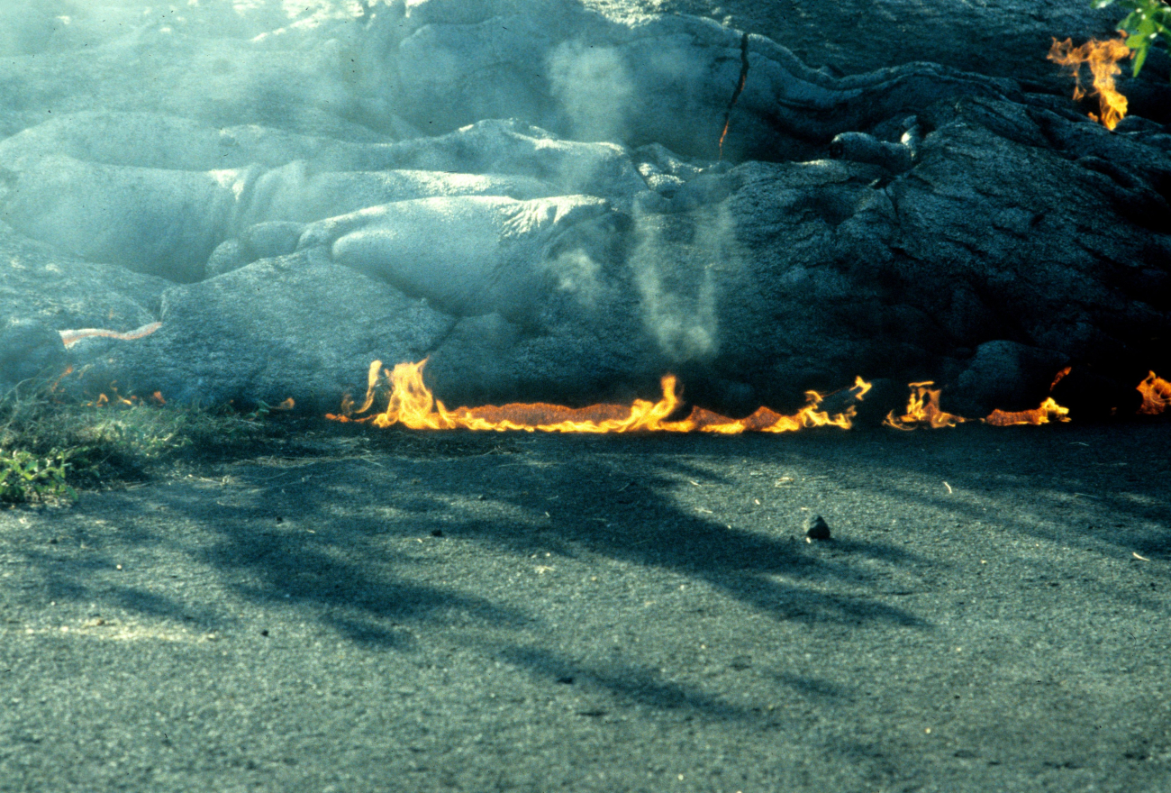 Lava encroaching on a highway and setting the oil in the asphalt on fire