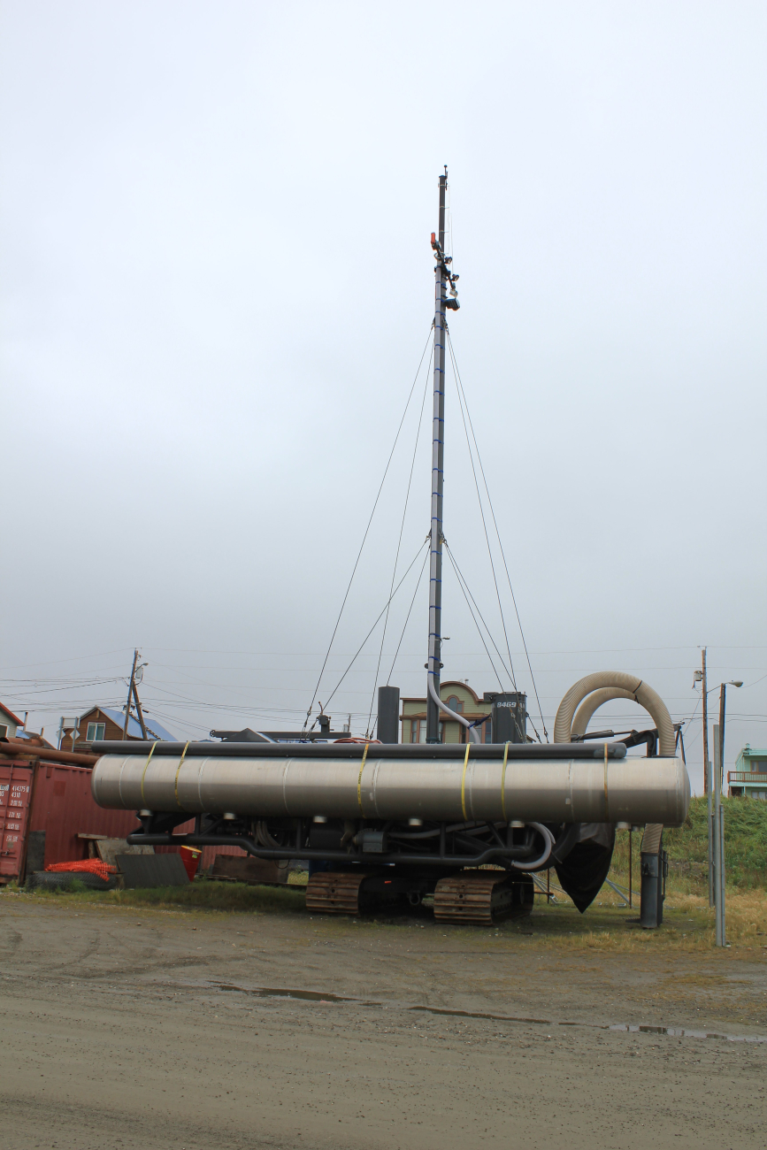 A floating metal pontoon boat that has been modified to run a gold dredge onthe Nome River
