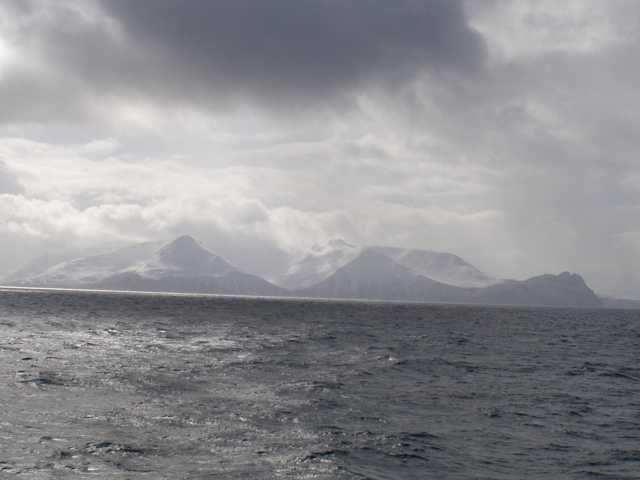 A typical Aleutian day with clouds, snow, and grey leaden sea